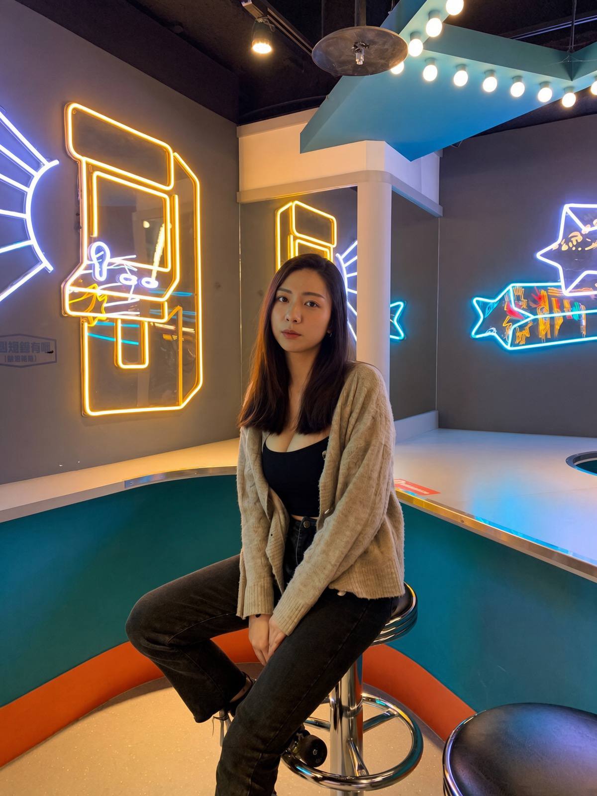 Knitting cardigans under neon lights during the day, sitting in a sweet laugh,